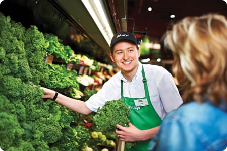An image of a Sobeys teammate assisting his customer in buying fresh vegetables.
